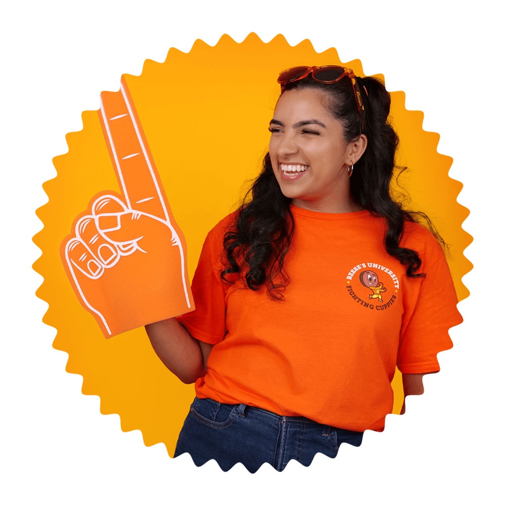 woman wearing reeses university branded clothing raising foam finger into the air