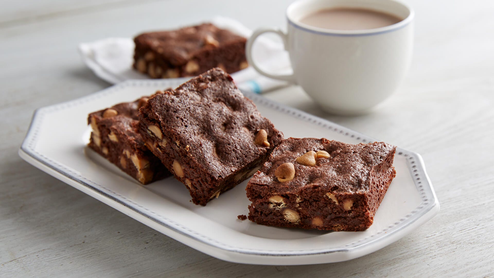 plate of gluten free brownies beside cup of tea