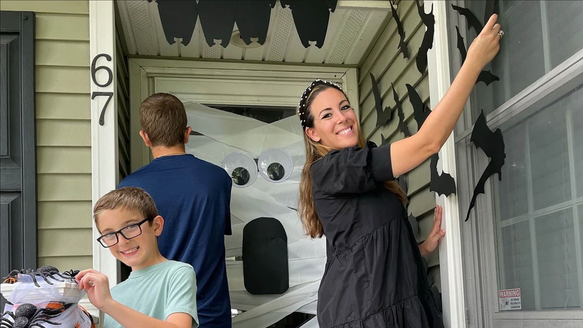 family decorating front door for halloween