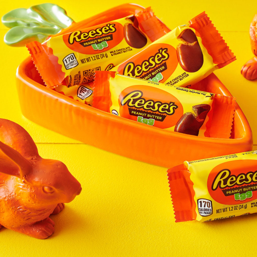 carrot shaped bowl filled with packs of reeses milk chocolate peanut butter eggs