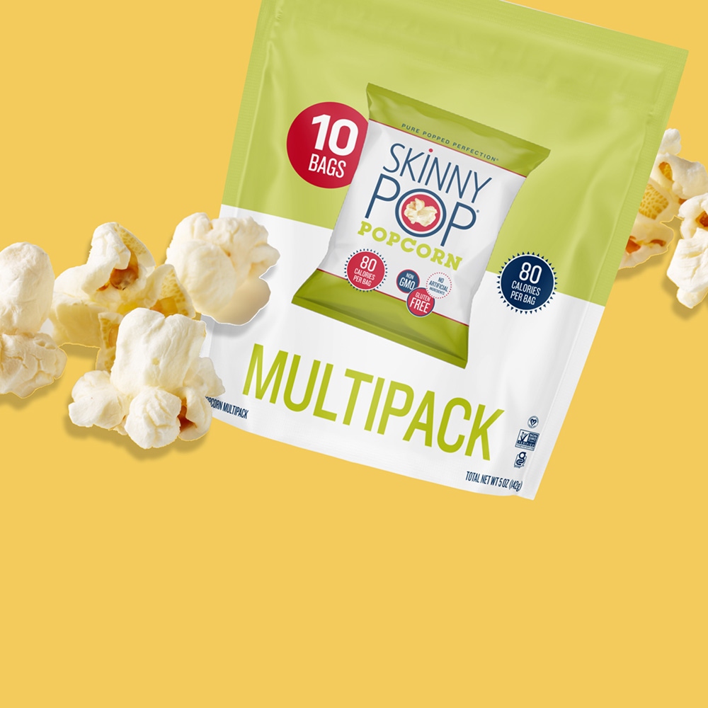 multipack of skinnypop original popped popcorn surrounded by unwrapped pieces of popcorn