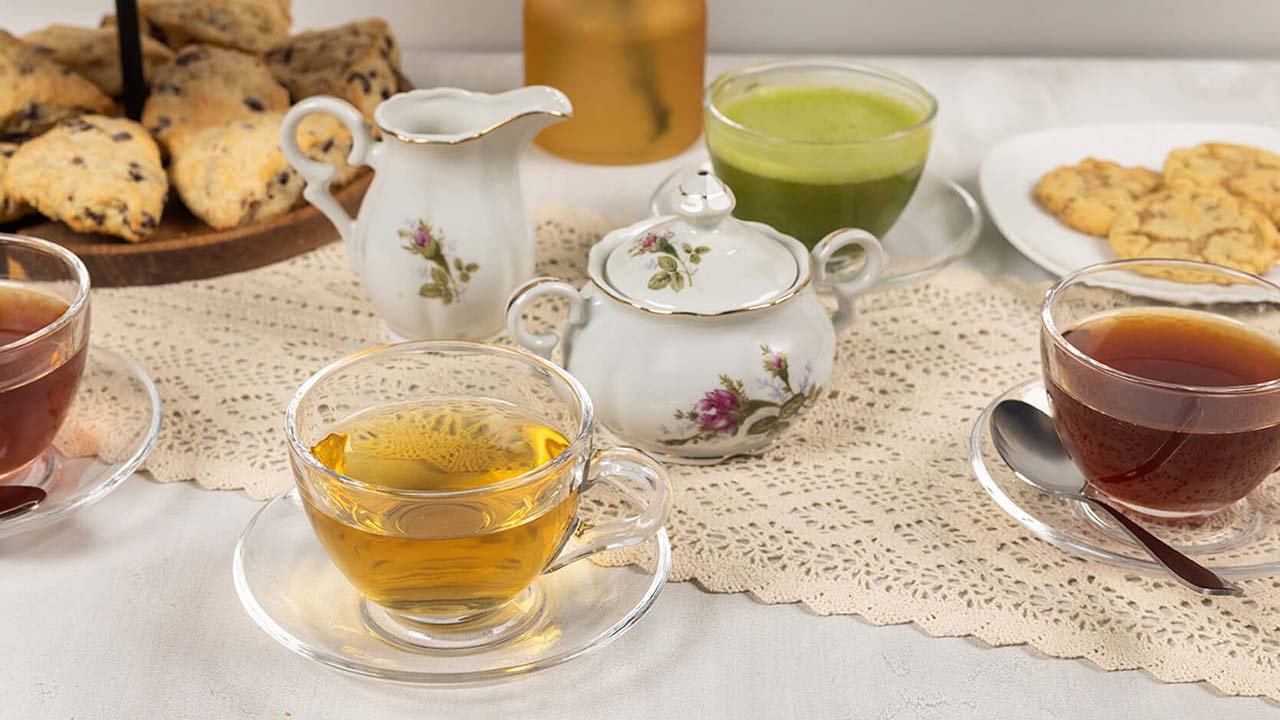 table topped with cups of assorted teas paired with baked goods