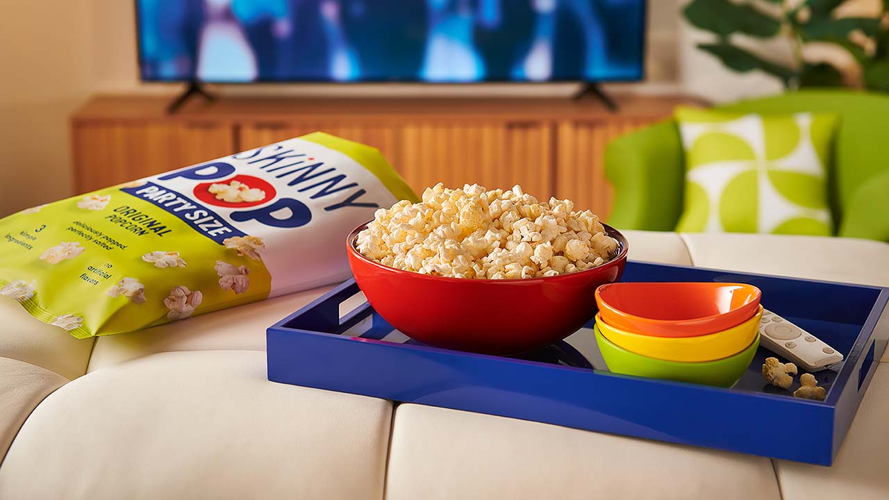 bowl filled with skinnypop original popcorn resting on an ottoman