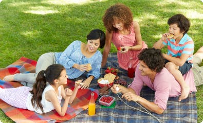 kids and adults enjoying smores on a picnic blanket