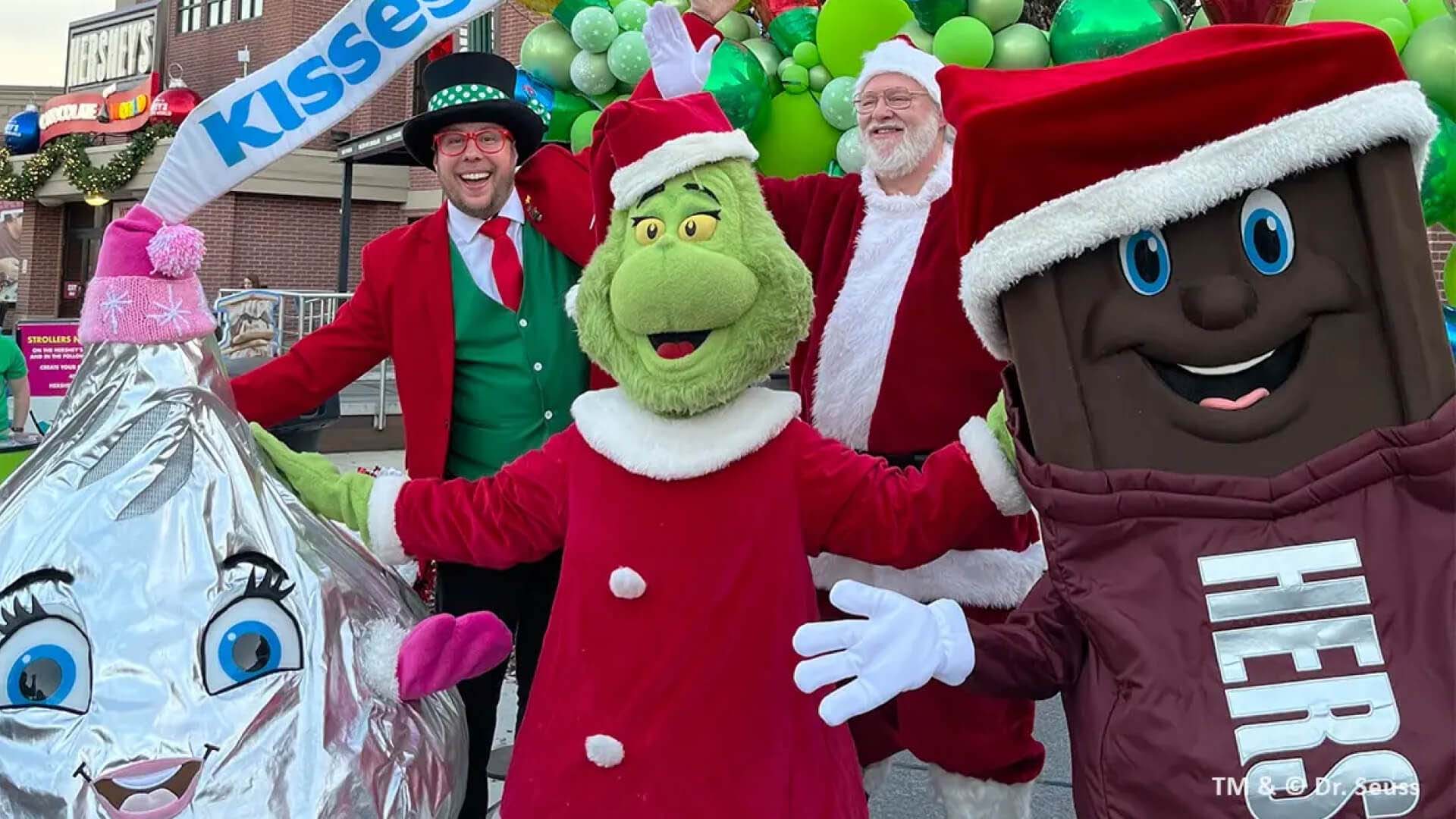 holiday mascots standing with the grinch and santa claus in front of hersheys chocolate world