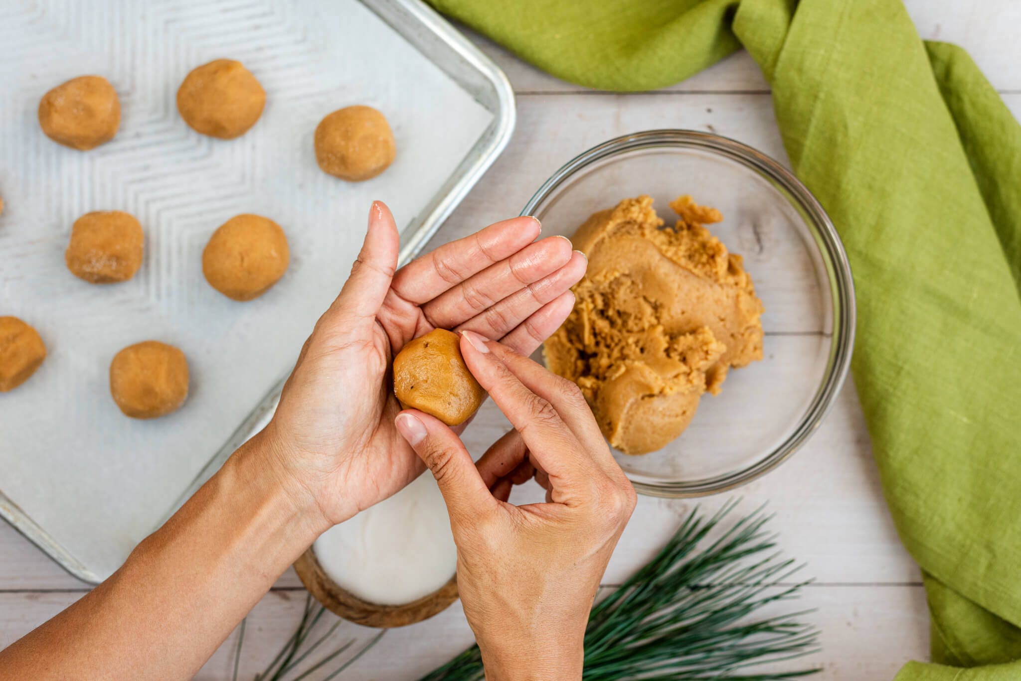 cookie dough being rolled into balls before baking