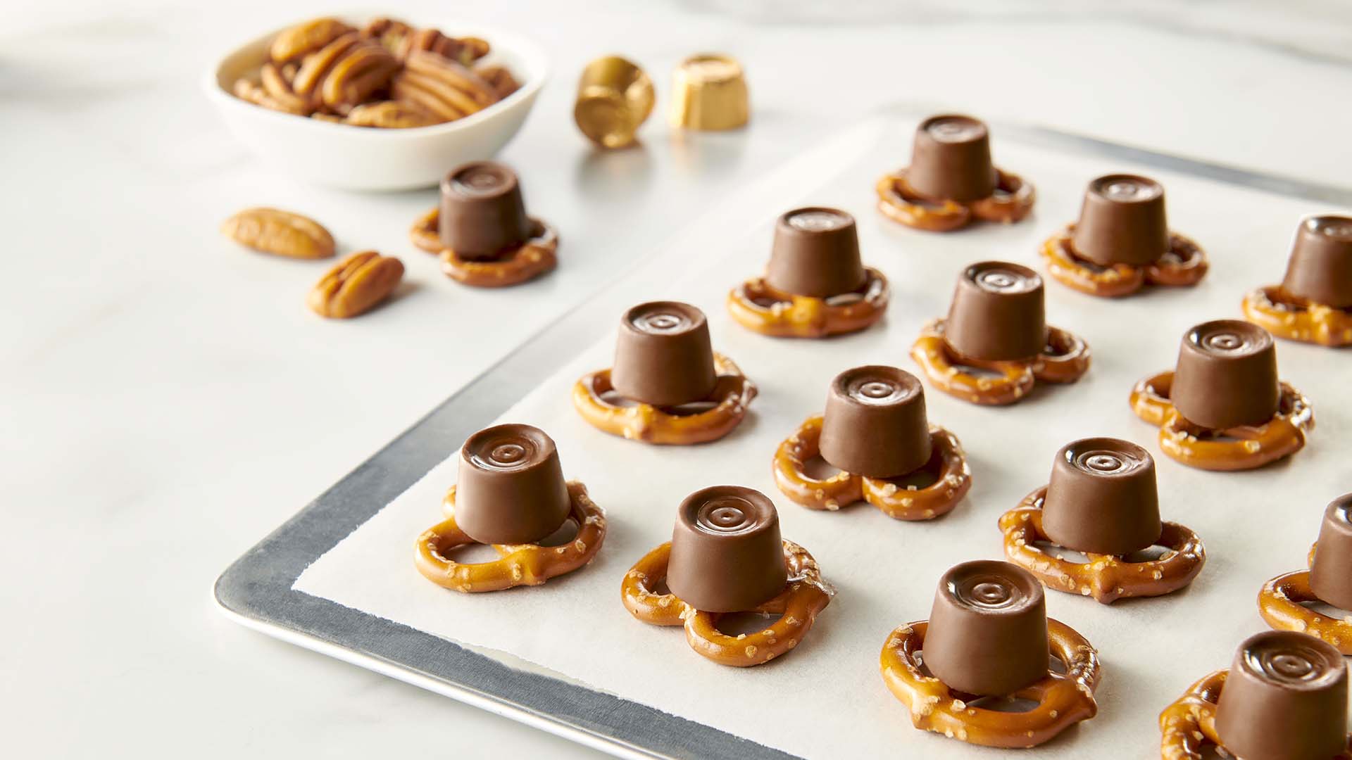 placing one unwrapped rolo creamy caramel on top of each pretzel