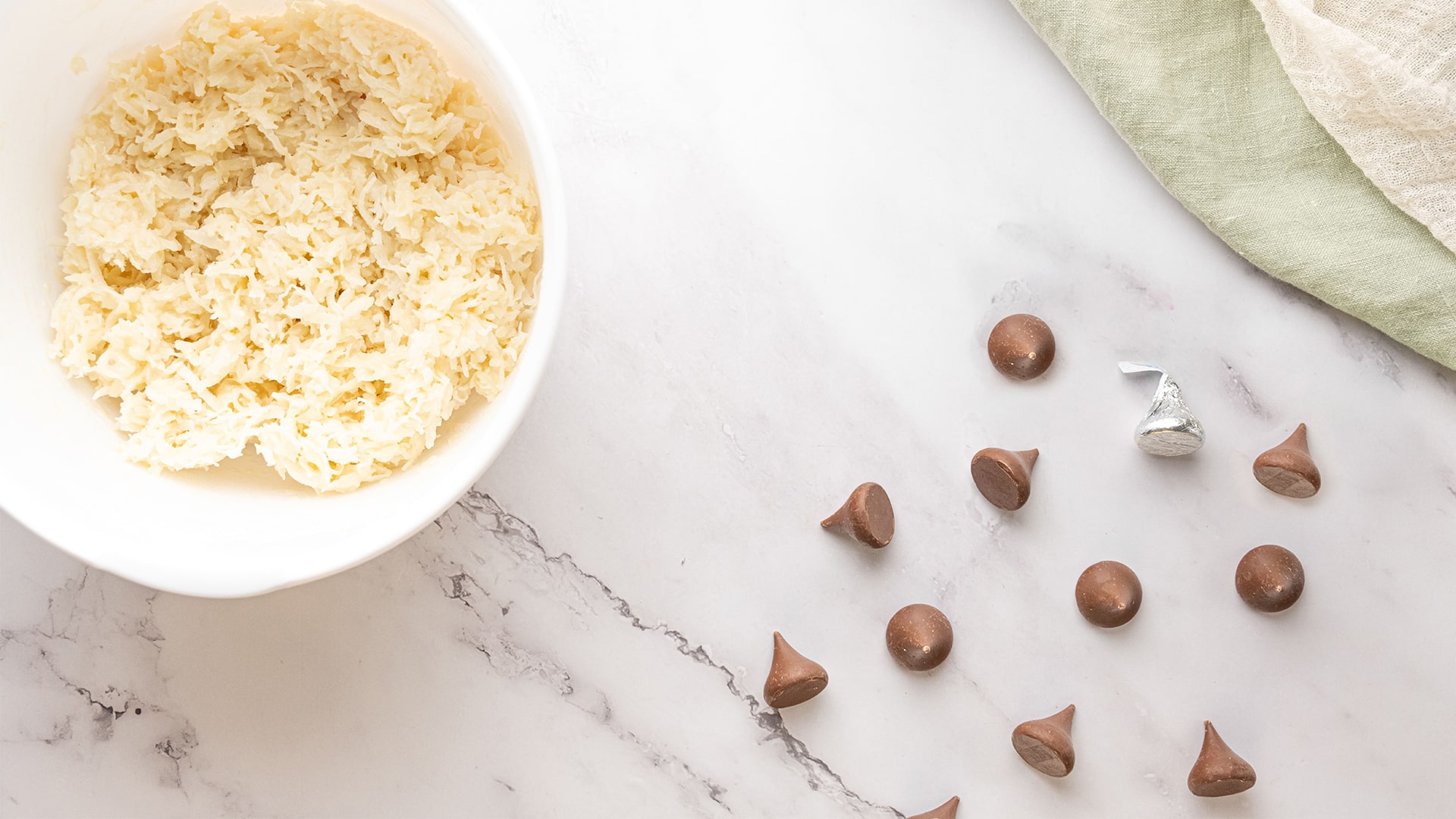 bowl of batter and unwrapped hersheys kisses laid out on table