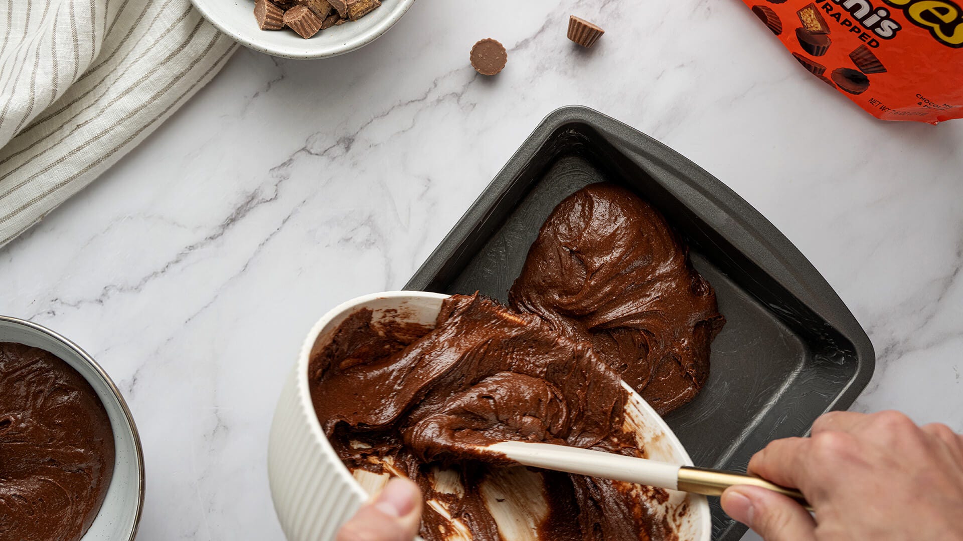 pouring brownie batter into pan