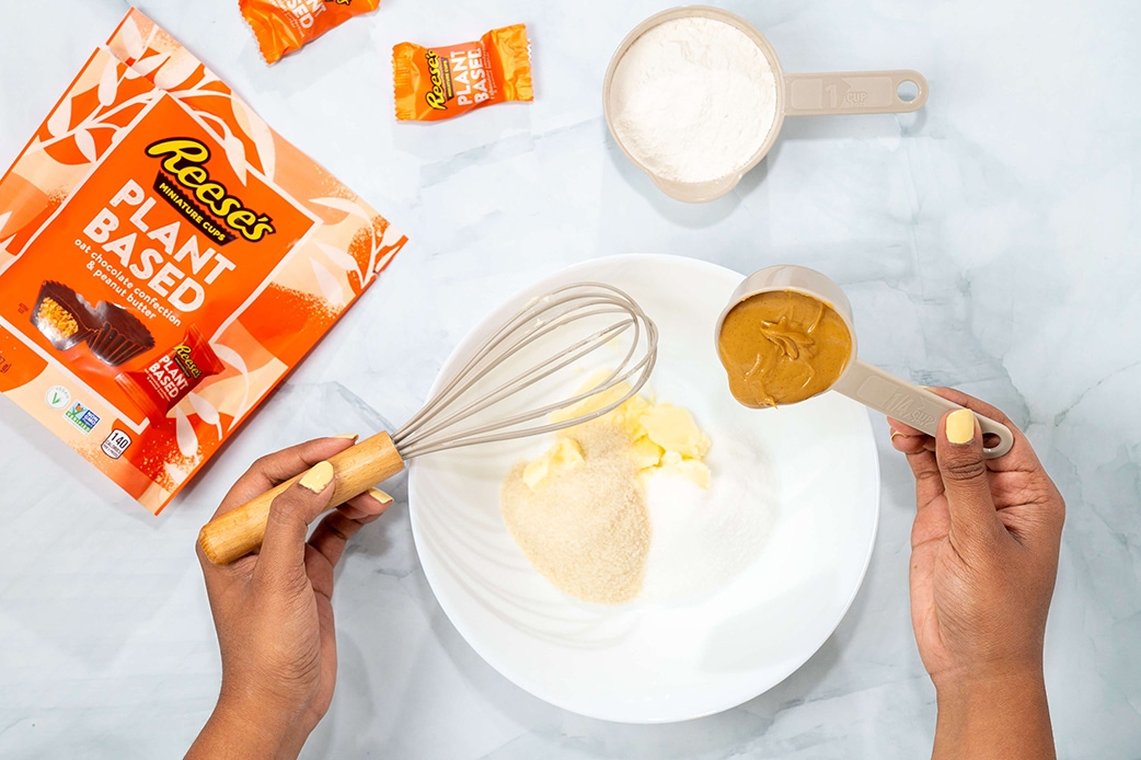 penaut butter being added to bowl of dry ingredients