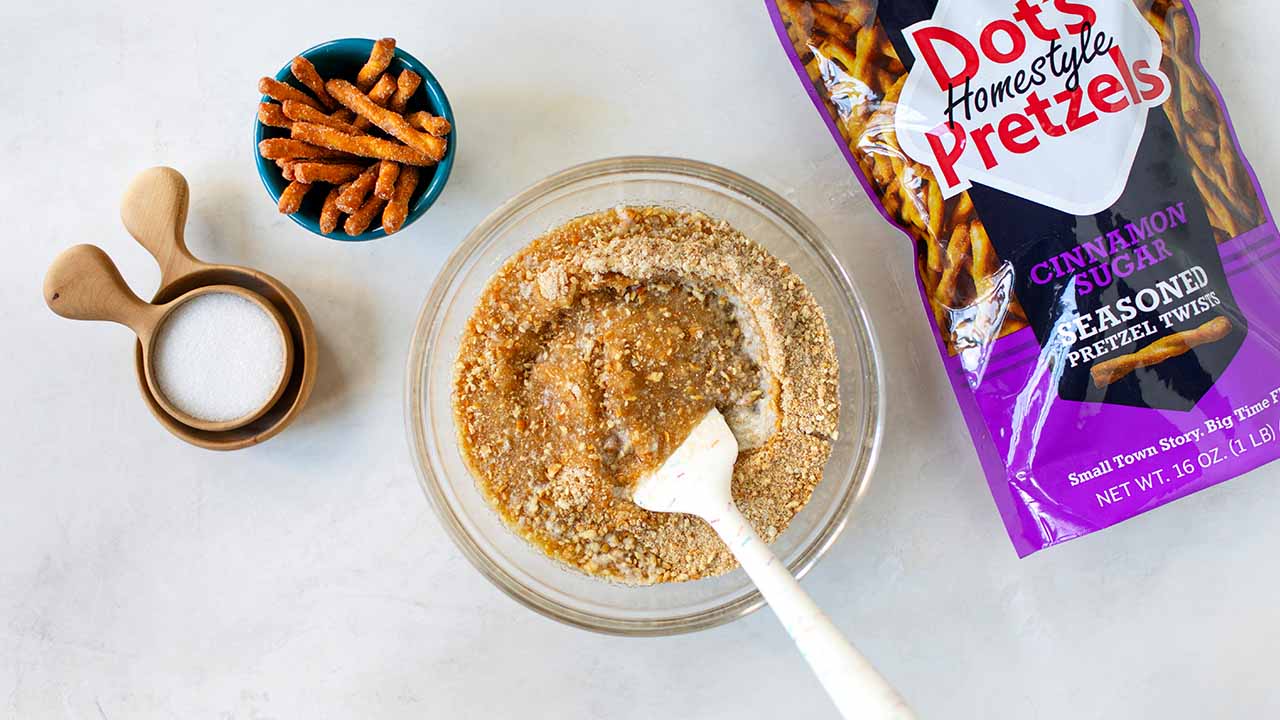 mixing together pretzels, butter, and sugar in a bowl