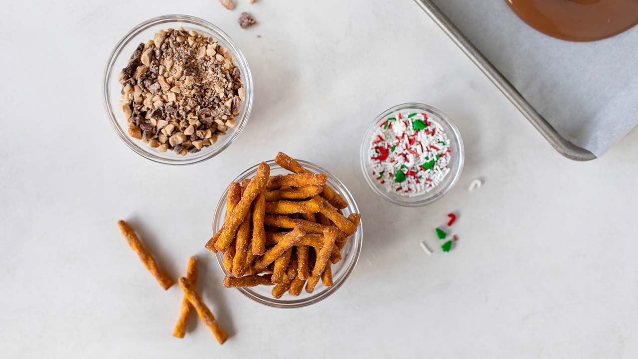 glass bowls filled with toffee bits, cinnamon pretzel twists, and sprinkles