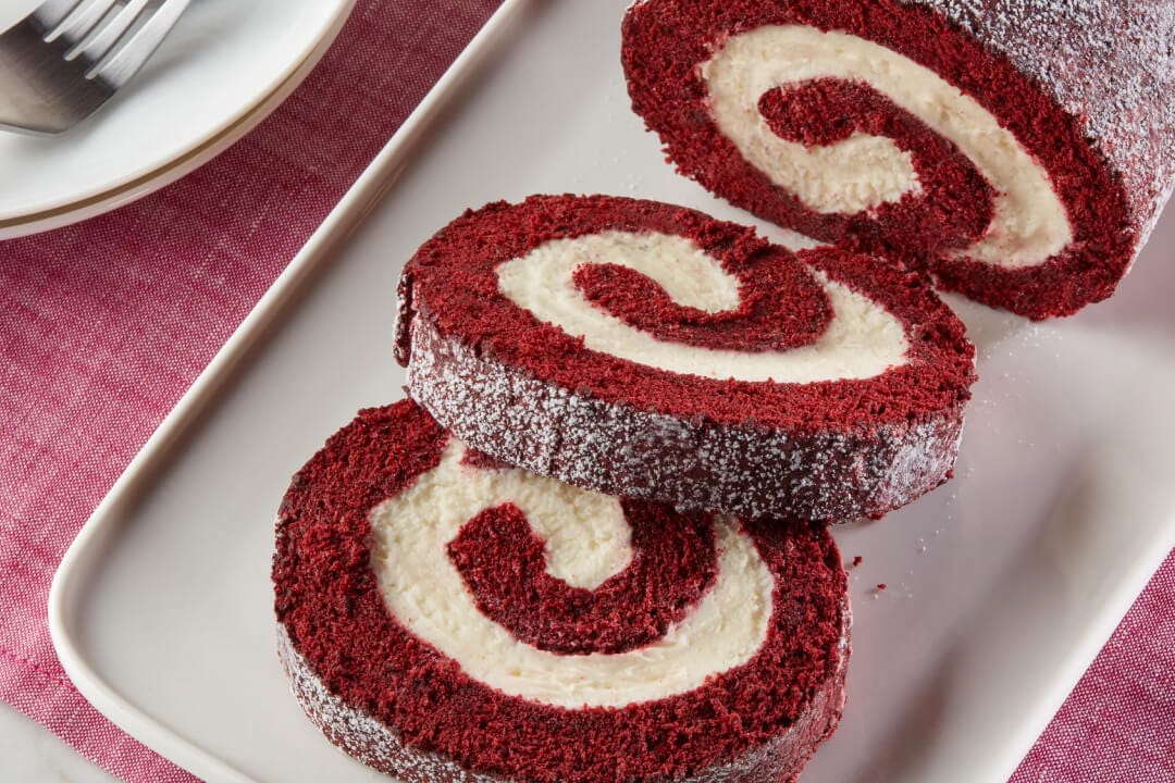 plated of red velvet cake roll cut into serving slices