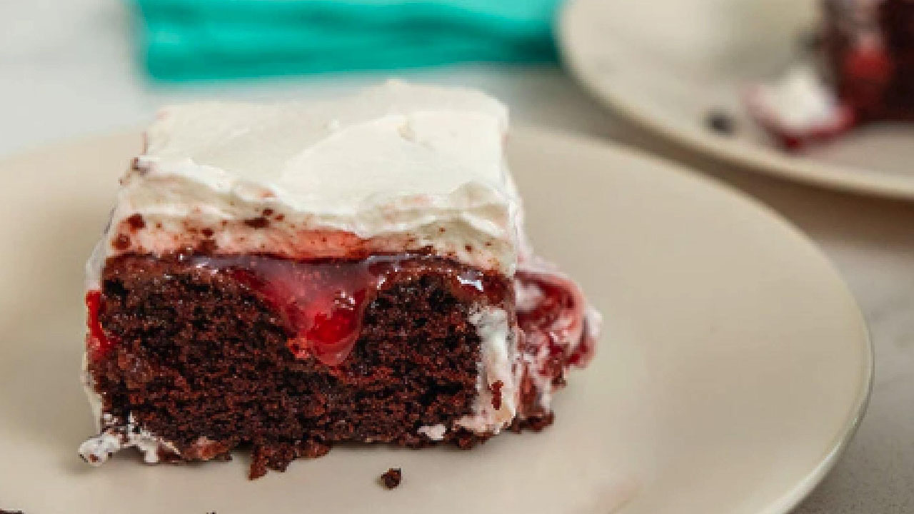 plate topped with a slice of black forest poke cake