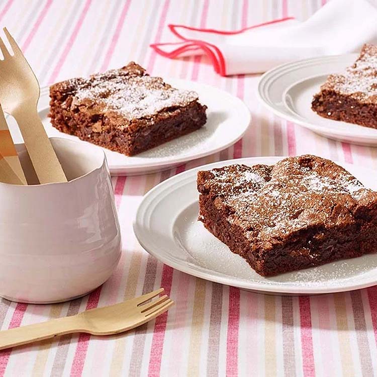 brownie squares topped with powdered sugar on serving dishes