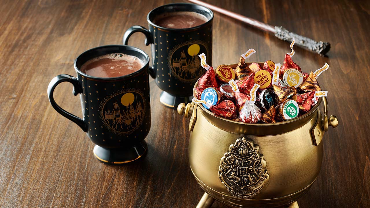 cauldron full of hersheys kisses harry potter foils milk chocolate candy beside two mugs of hot cocoa