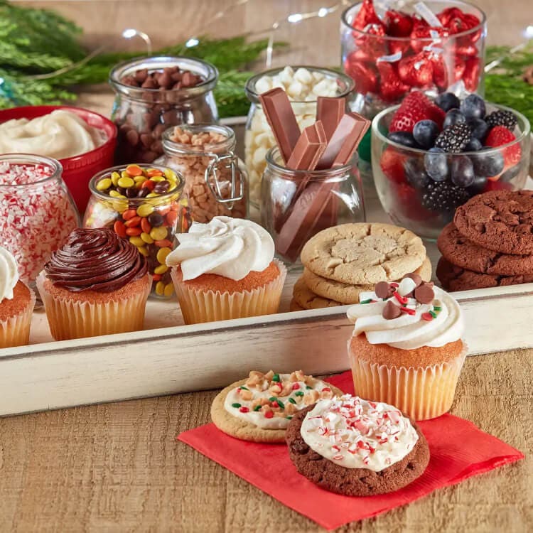 dessert tray filled with baked goods, jars of candy, and toppings