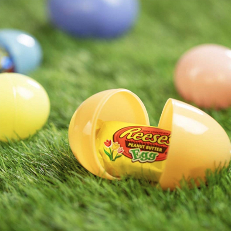 plastic easter egg opened and filled with reeses peanut butter egg