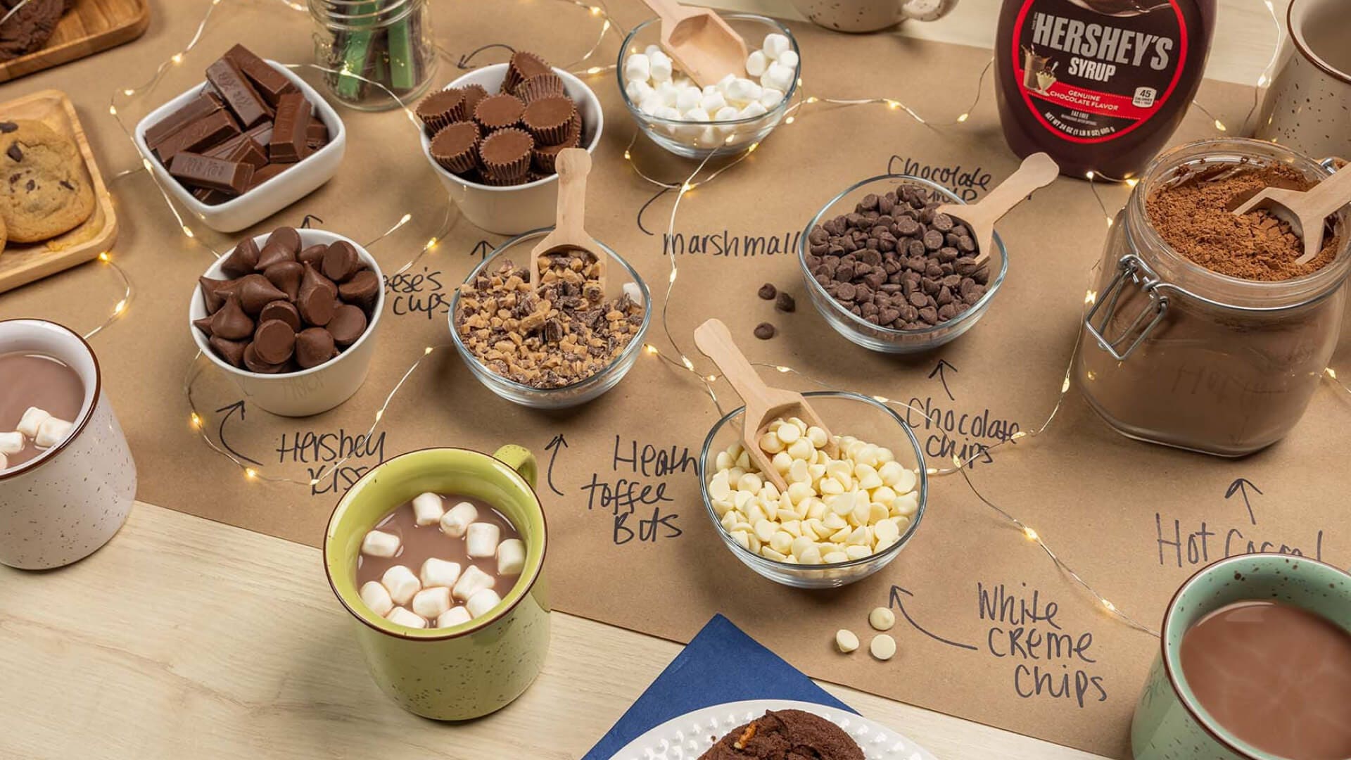 hot chocolate bar filled with bowls of assorted hersheys candies and toppings