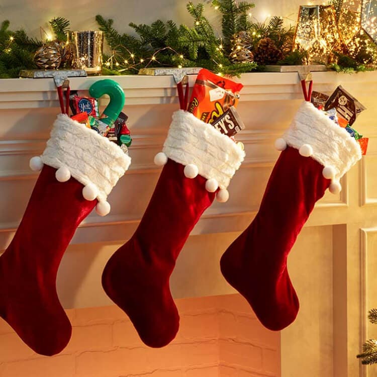 stockings filled with assorted hersheys candy hanging on mantle