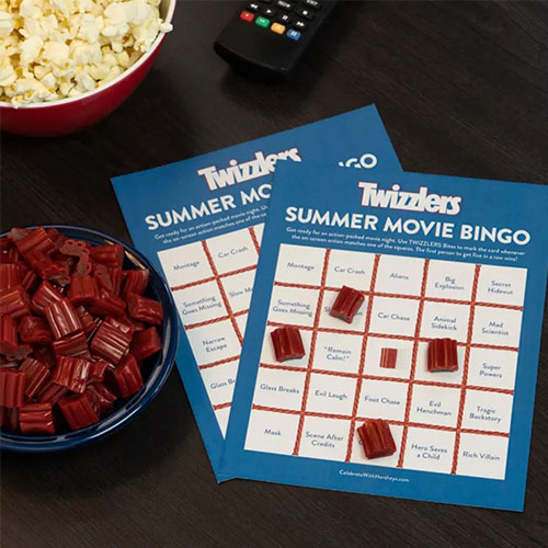 bowl of twizzlers nibs beside twizzlers themed movie night bingo cards