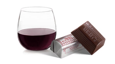 glass of red wine paired with hersheys dark chocolate nuggets